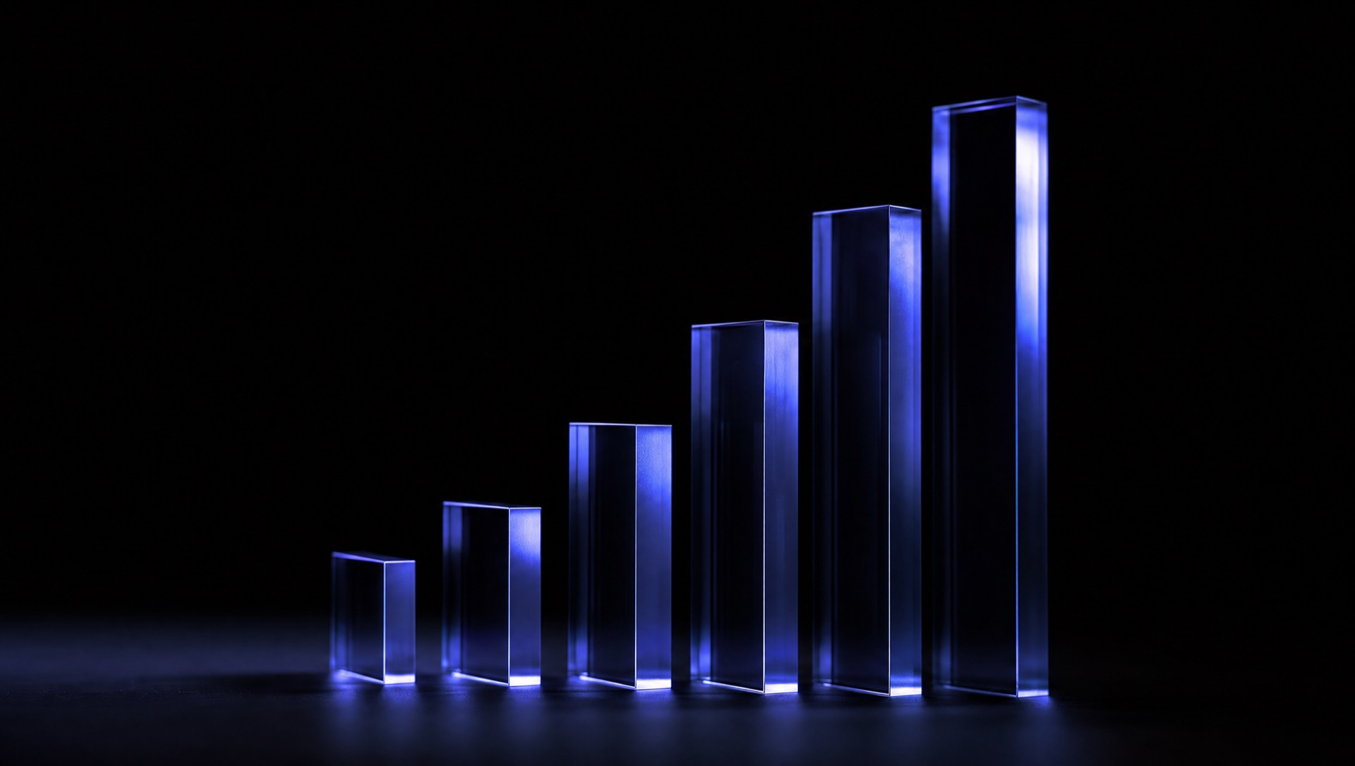 Glass bar chart rising from a black surface, lit indigo